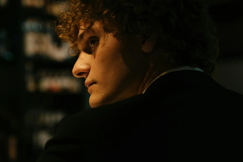 a close up of a person with a cell phone, inspired by Nan Goldin, renaissance, joe keery, posed in profile, noir film still, [ theatrical ]