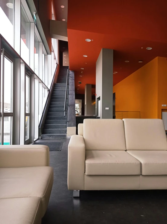 modern living room with beige couches and orange walls