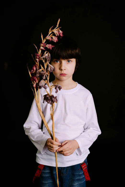 a young boy holding a bunch of flowers, unsplash, hyperrealism, orchid stems, somber expression, press shot, clothes made out of flower