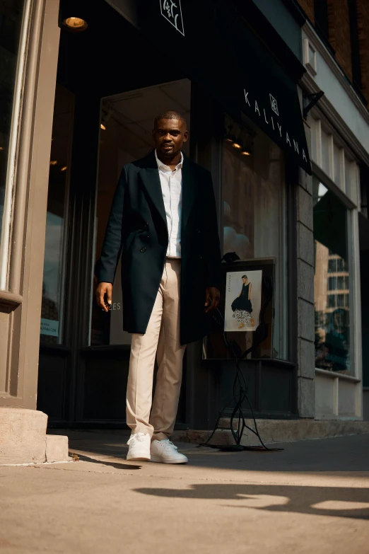 an african american man in a black coat and brown slacks