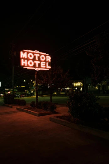 the motel sign is lit up at night
