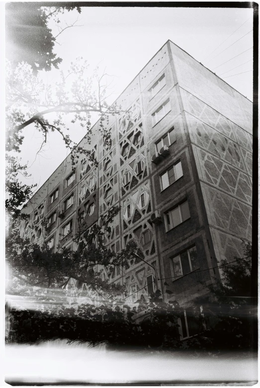 a black and white photo of a tall building, a black and white photo, inspired by André Kertész, holga 120n, decorated with soviet motifs, kreuzberg, 35mm!!! 1990