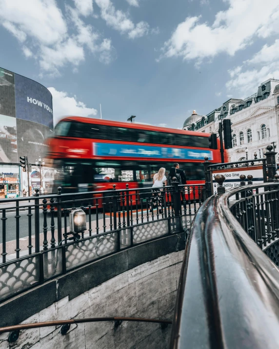 a red double decker bus on a city street, by Emma Andijewska, pexels contest winner, happening, billboards, square, random circular platforms, vogue cover photo