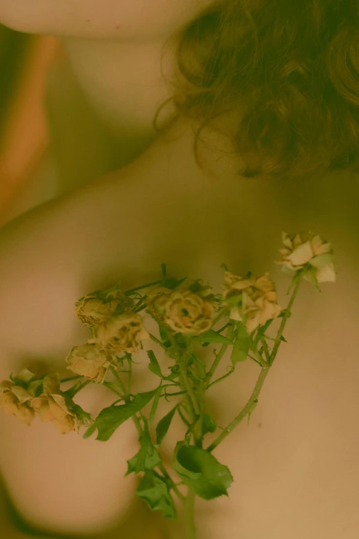 a close up of the face and chest of a woman with flowers on her chest