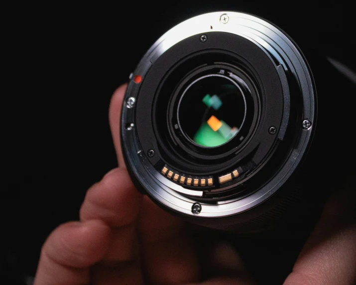 a close up of a person holding a camera lens, by Matthias Stom, unsplash, photorealism, large sensor dslr photo, high speed camera, 4 5 mm. photorealistic, canon 24mm