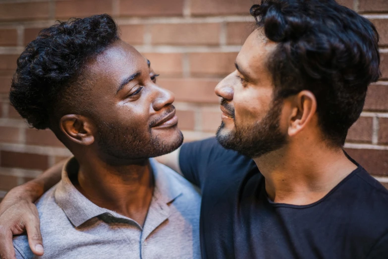 two men standing next to each other in front of a brick wall, trending on unsplash, kissing each other, varying ethnicities, sideburns, actors