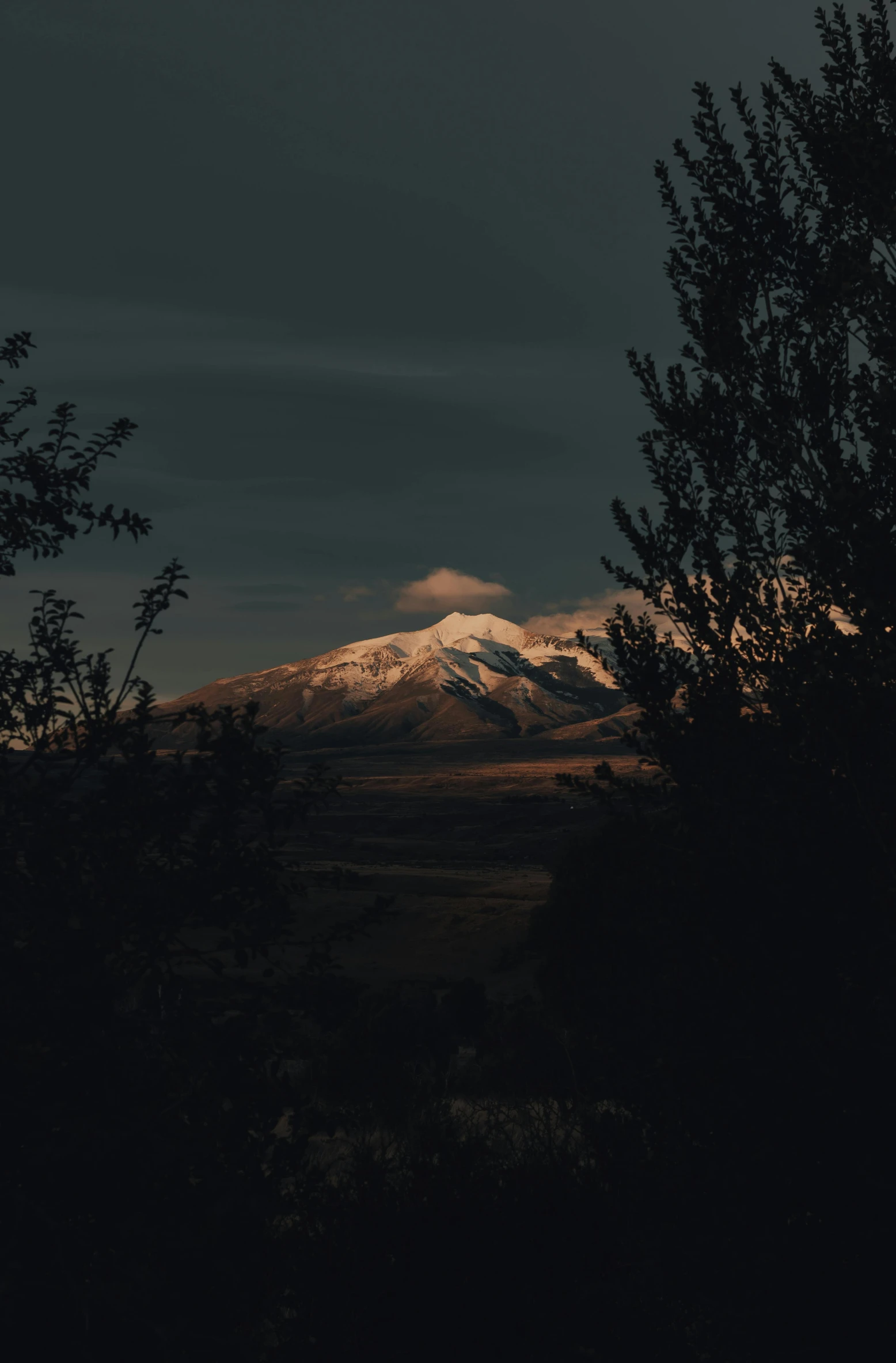 the view of mountains in the distance under dark clouds