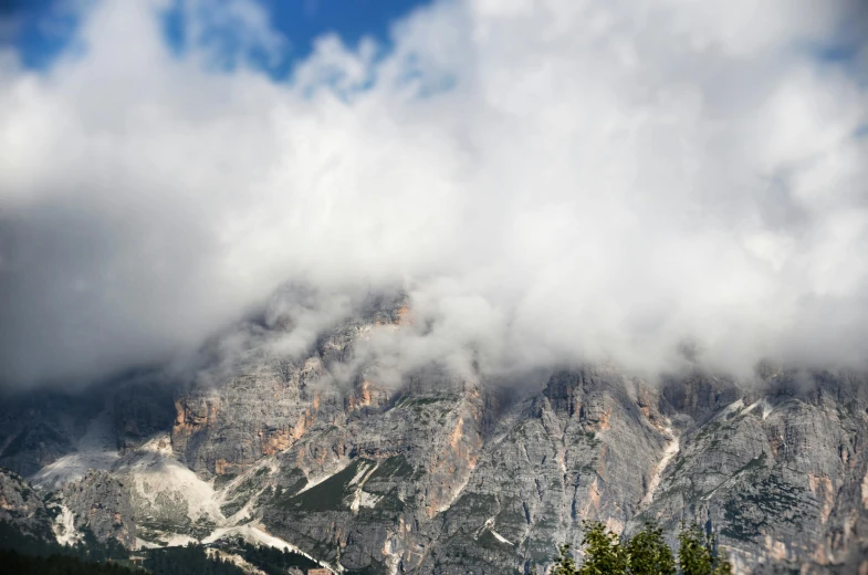 clouds are hovering over the mountain tops