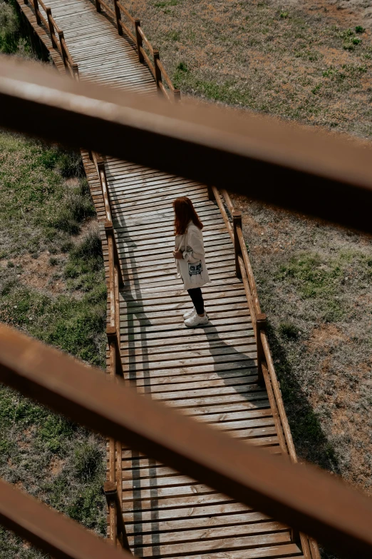 a  walking on a boardwalk over grass