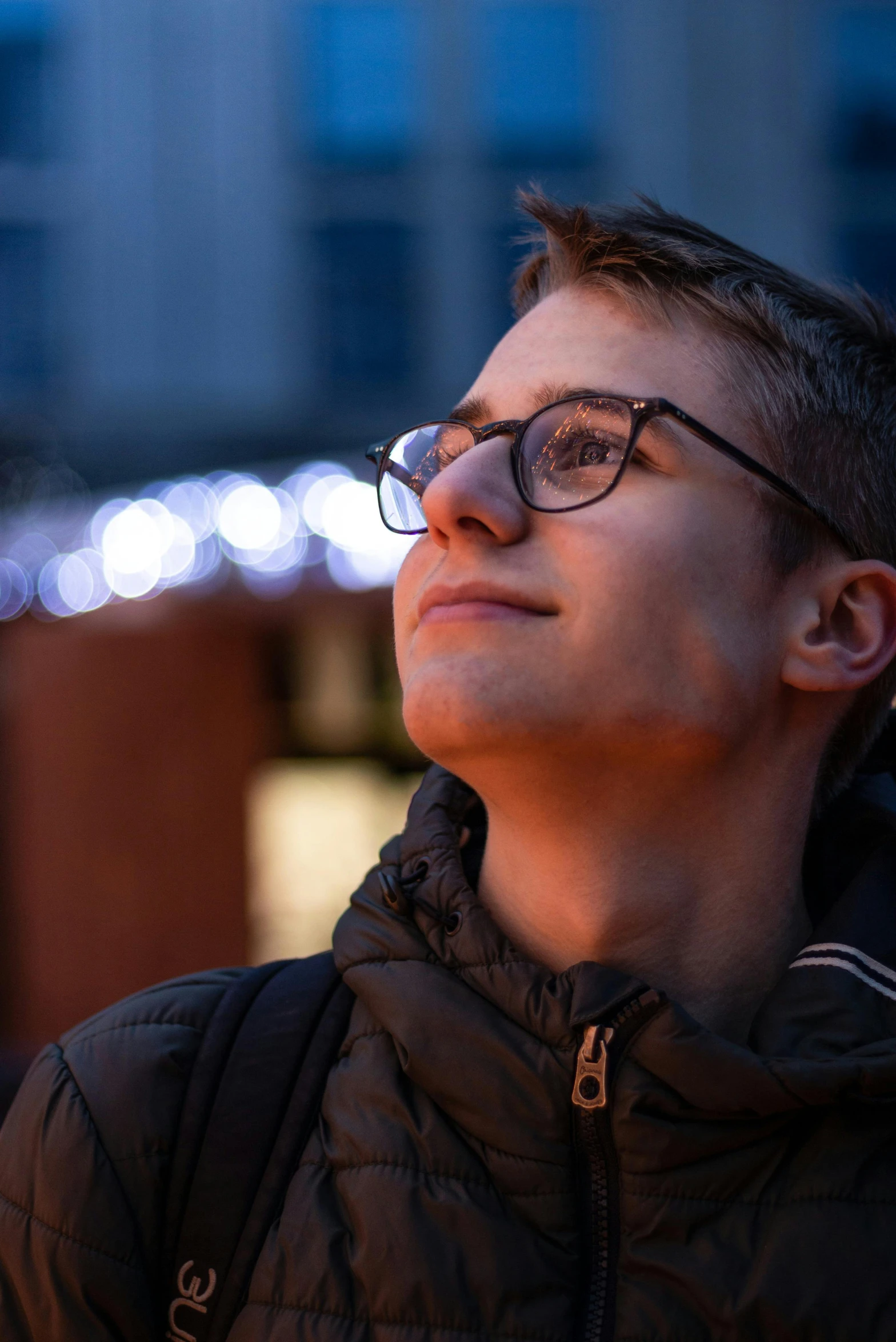 a man in glasses is looking away from the camera