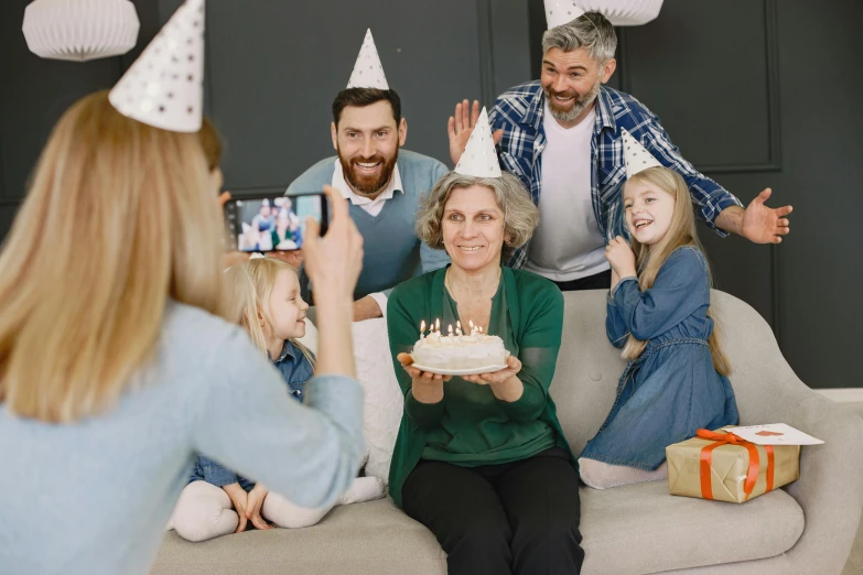a group of people sitting on top of a couch, a picture, birthday cake on the ground, 4k press image, middle aged, party hats