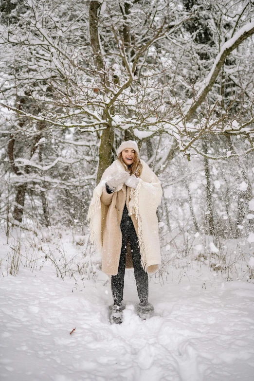 a woman in a winter coat standing in the snow