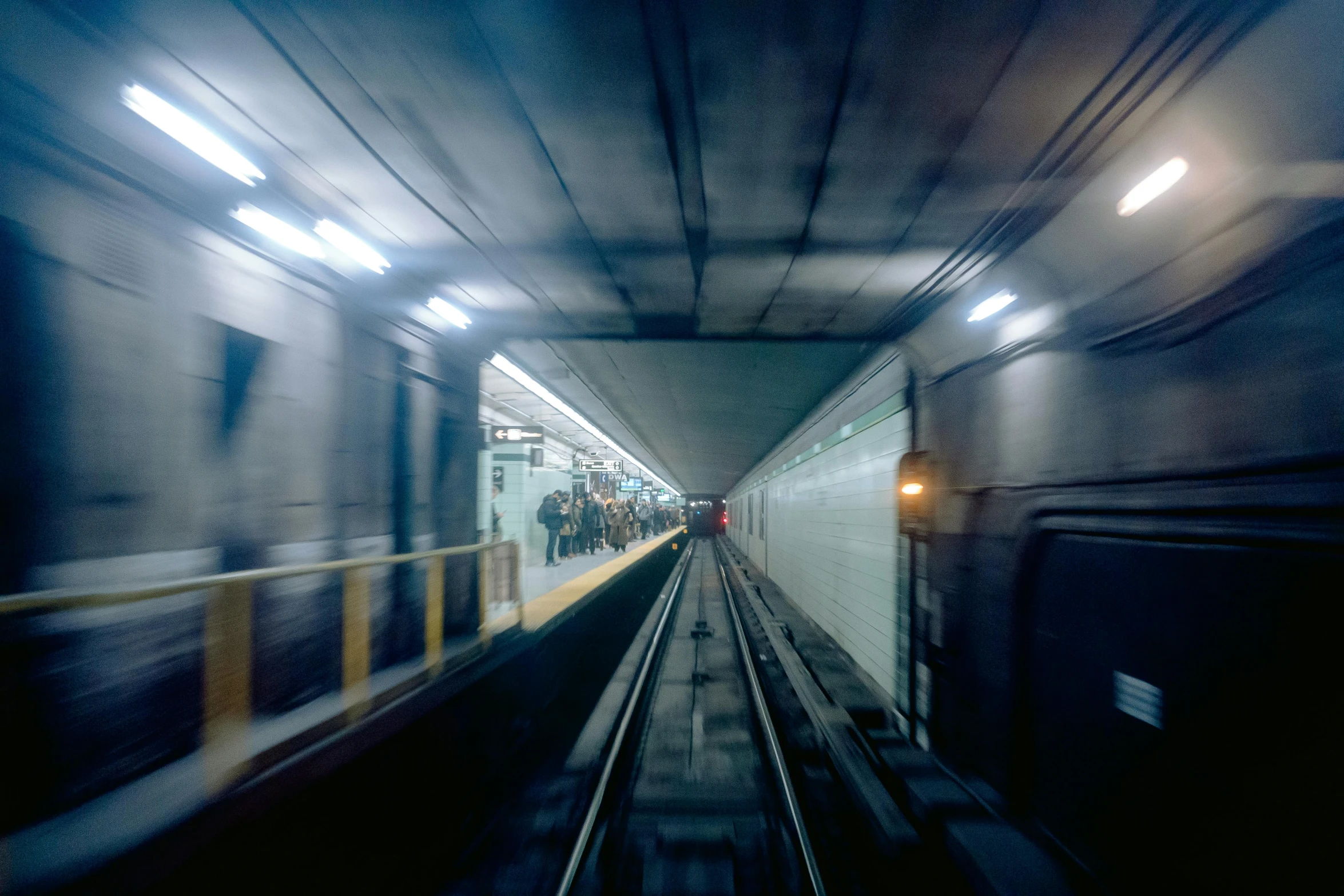 a train is passing by on a tunnel with people