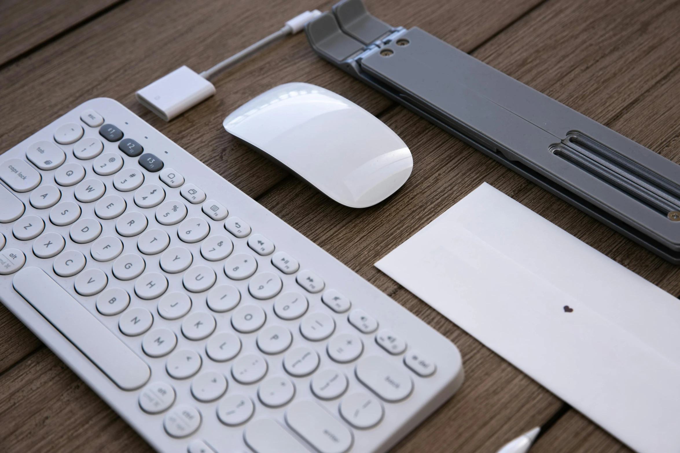 a keyboard and mouse sitting on top of a wooden table, various items, white and grey, slide show, brick