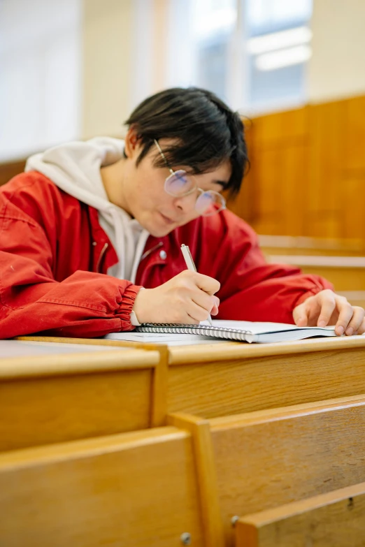 a man sitting at a desk writing on a piece of paper, by Jang Seung-eop, academic art, wearing a red hoodie, lgbtq, japanese high school, thumbnail