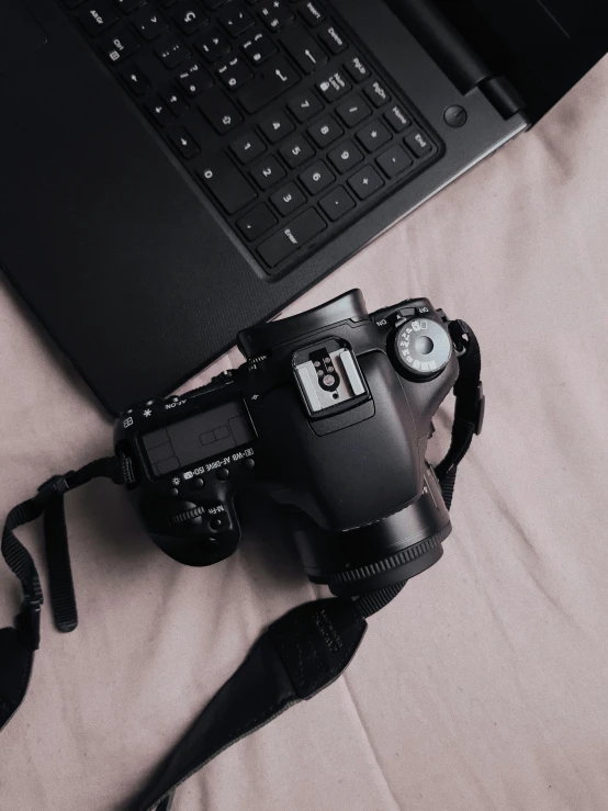 a laptop computer sitting on top of a bed next to a camera, a picture, looking down on the camera, canon eos 7 d, unsplash transparent, body and headshot