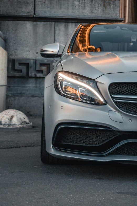 close up of a silver mercedes benz c class coupe with headlight and bumper rings