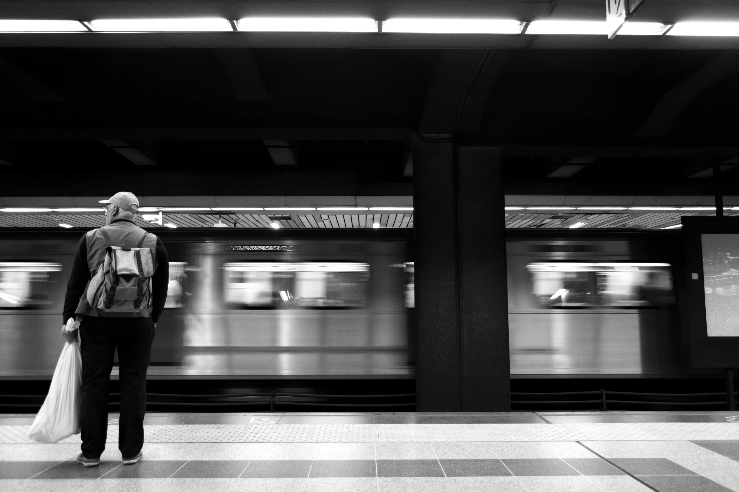 a black and white photo of a person waiting for a train, by Silvia Pelissero, unsplash, fan favorite, couple, hugging, underground metro