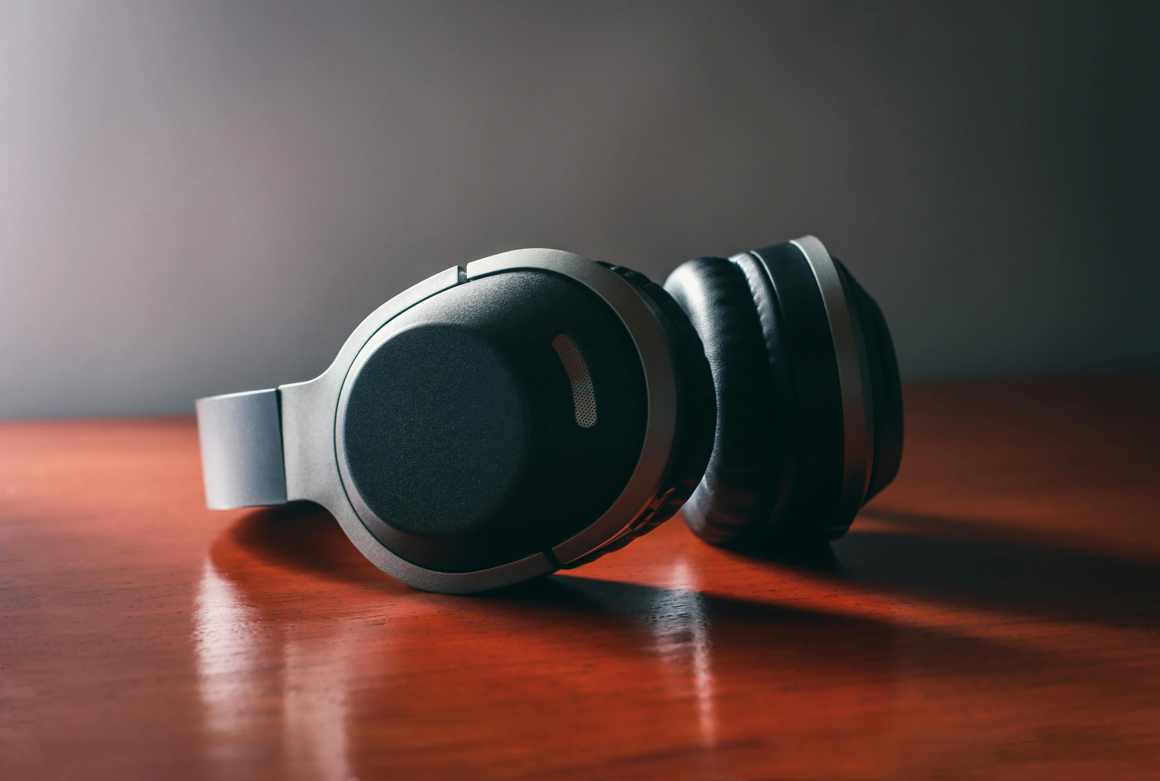 a pair of headphones sitting on top of a wooden table, trending on pexels, black lacquer, thumbnail, high - poly, cinematic shot