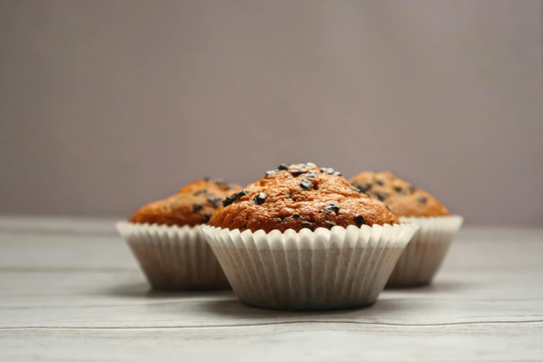 a couple of muffins sitting on top of a wooden table, pexels, hyperrealism, background image, thumbnail, upscaled to high resolution, 6 pack
