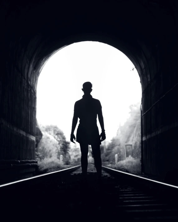 a man that is standing in the middle of a tunnel, a black and white photo, pexels contest winner, romanticism, an epic non - binary model, not train tracks, outlined silhouettes, instagram post