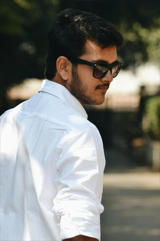 a close up of a man in white shirt and sunglasses