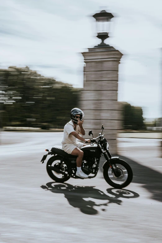 a man riding on the back of a motorcycle down a street, pexels contest winner, deus ex machina, madrid, teenage girl, beautiful surroundings