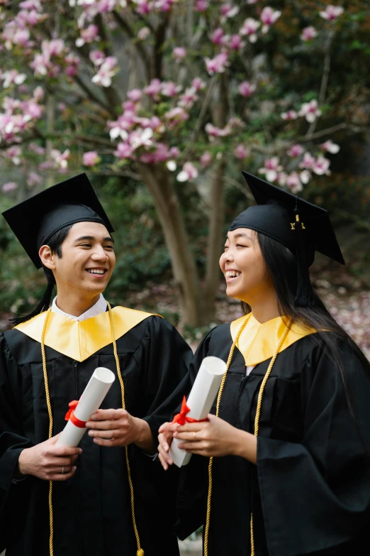 a group of people standing next to each other holding diplomas, a portrait, by Carey Morris, shutterstock, academic art, trees in background, asian male, twins, both laughing