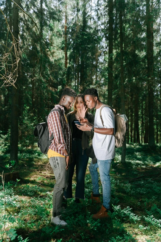 a couple of men standing next to each other in a forest, pexels contest winner, happening, integrating with technology, black man, three views, college students