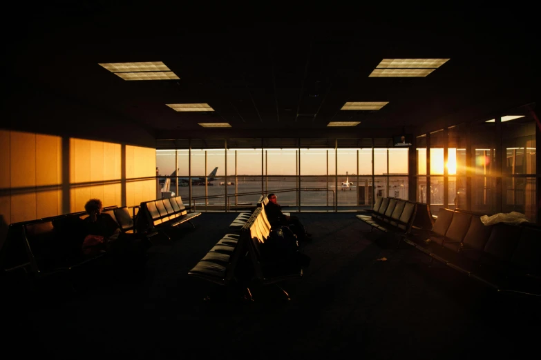 a group of people sitting next to each other at an airport, by Tobias Stimmer, pexels contest winner, modernism, sun down, looking out window, calm afternoon, carson ellis