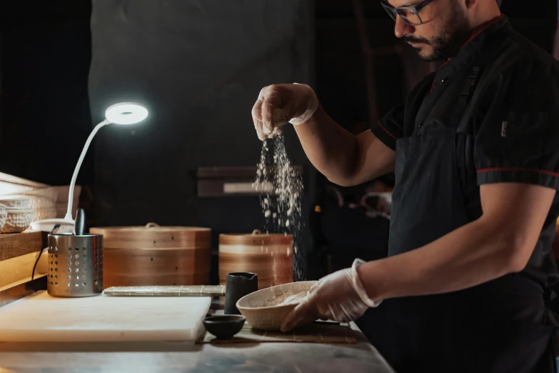 a man standing in a kitchen preparing food, a portrait, inspired by Kanō Naizen, trending on unsplash, woodfired, an island made of caviar, avatar image, woodturning