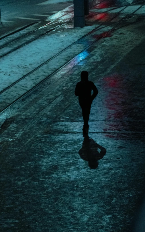 a person walking down a street at night, by Matt Stewart, pexels contest winner, conceptual art, wet reflective ground, people running, cold blue light, silhouette :7