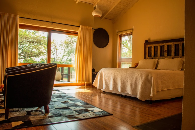 an empty bedroom with a bed, window and large rug