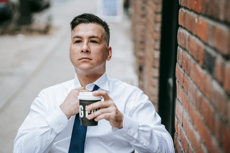 a man standing on the side of a brick wall