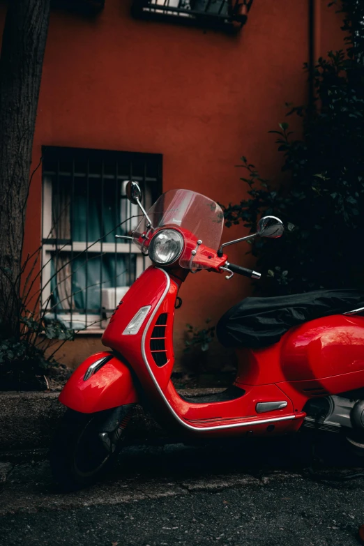 the moped is parked beside the building next to it