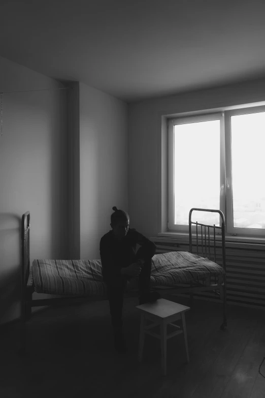 a person sitting in a small bed room