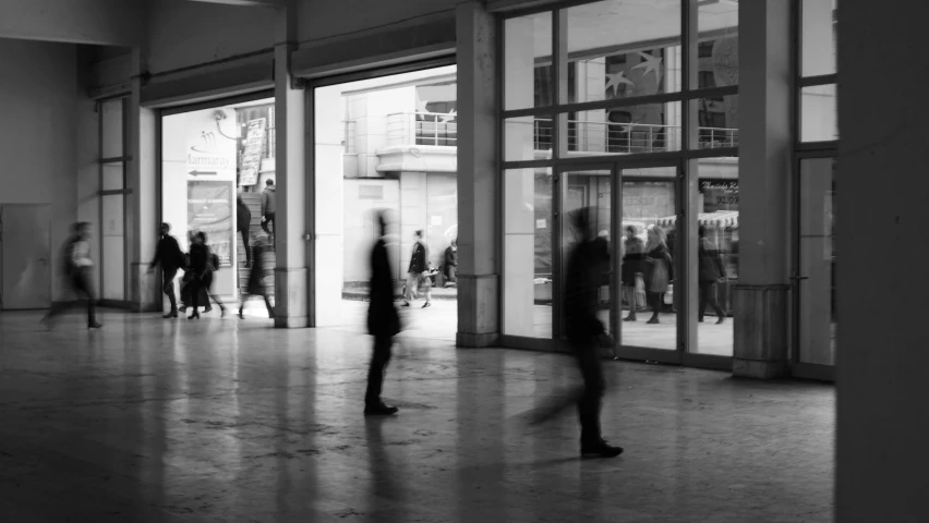 a black and white photo of people walking in a building, a black and white photo, retaildesignblog, thumbnail, multiple stories, people running