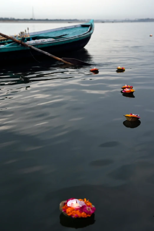 a row boat sitting on top of a body of water, by Sunil Das, minimalism, petals falling, toys, harbor, unedited