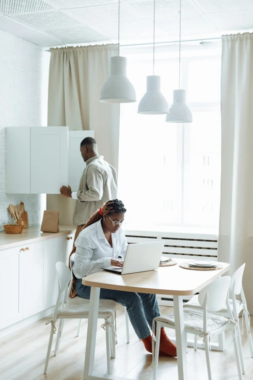 two people at a table working on laptops