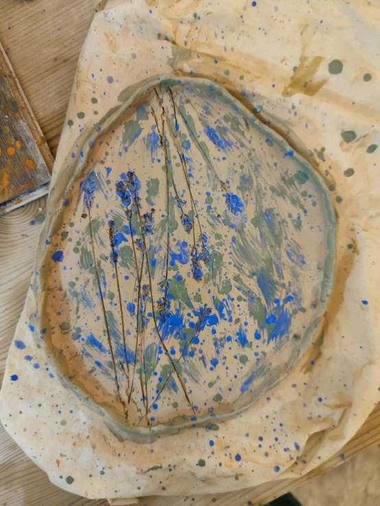 a close up of a plate on a table, inspired by Mordecai Ardon, process art, mediumslateblue flowers, clay material, splash image, ilustration