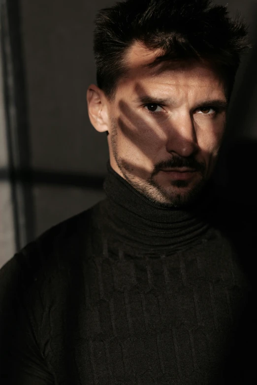 a man in a black turtle neck shirt, inspired by Camilo Egas, trending on pexels, bauhaus, melanchonic soft light, looking seductive, football, escher mc