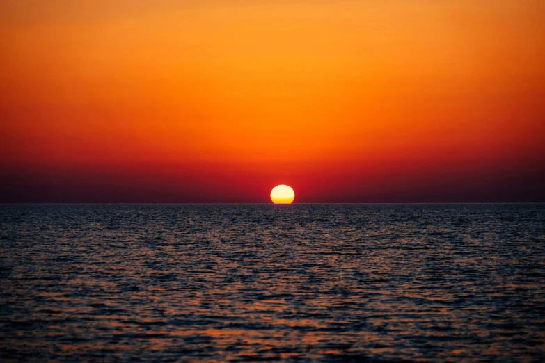 the sun is setting over the ocean, a picture, unsplash, romanticism, red and orange glow, mediterranean, 8k resolution”