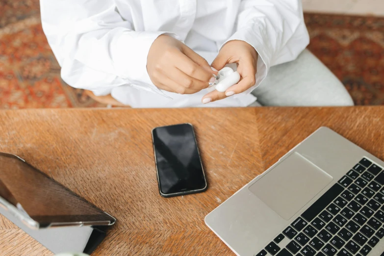 a person sitting at a table with a laptop and cell phone, glue dropping, quack medicine, detailed product image, white