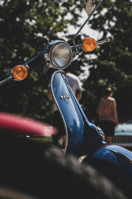 a blue motor scooter parked in a parking lot, by Matt Cavotta, pexels contest winner, photorealism, tail lights, close up head shot, festivals, vintage car