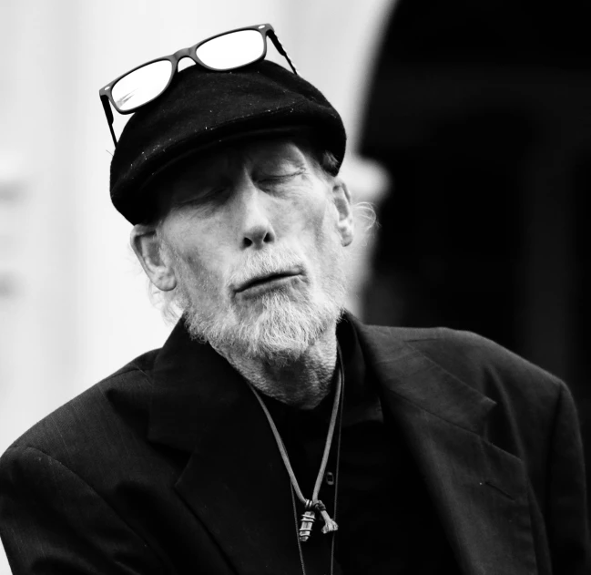 a black and white photo of a man wearing a hat, a black and white photo, inspired by John Bellany, pixabay, modernism, an old man with a ginger beard, eyes closed, jean deville, william gibson