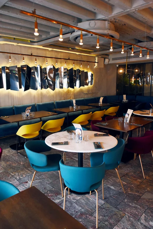 large tables and chairs in an empty restaurant with blue walls