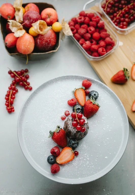 a white plate topped with fruit next to bowls of berries, pexels contest winner, romanticism, cake art, seasonal, sugar sprinkled, full product shot