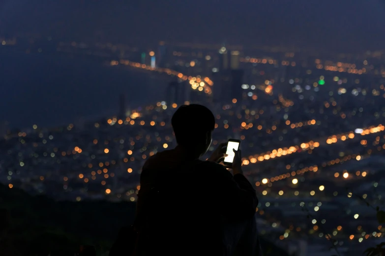 a person taking a picture of a city at night, happening, hazy, light on top, lights off, rectangle