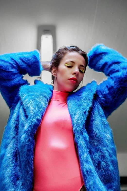 a woman in a blue fur coat posing for a picture, an album cover, inspired by Julia Pishtar, trending on pexels, pop art, aubrey plaza, skin : tjalf sparnaay, bright light, toiletpaper magazine