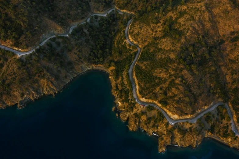 an aerial view of a winding road next to a body of water, pexels contest winner, realism, turkey, early evening, cliffside, thumbnail